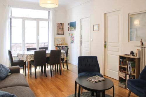 un salon avec une table et des chaises dans l'établissement Spacious family nest facing Square des Épinette, à Paris