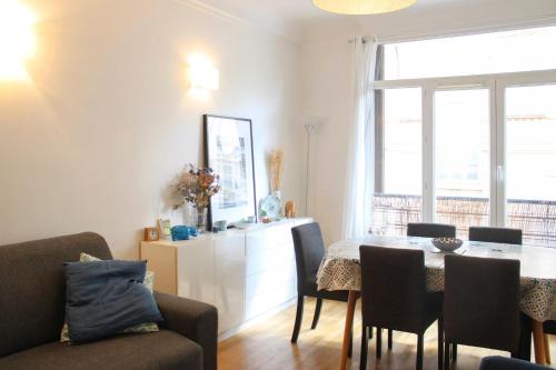 un salon avec une table et des chaises et une fenêtre dans l'établissement Spacious family nest facing Square des Épinette, à Paris