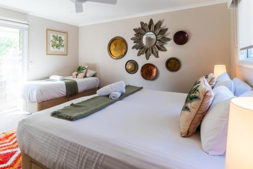 a bedroom with two beds and a mirror on the wall at Hunter Moon Country House, Hunter Valley in Broke
