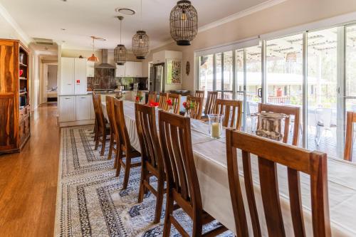 a kitchen and dining room with a long table and chairs at Hunter Moon Country House, Hunter Valley in Broke