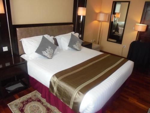 a bedroom with a large bed with white sheets and pillows at Saro Maria Hotel in Addis Ababa