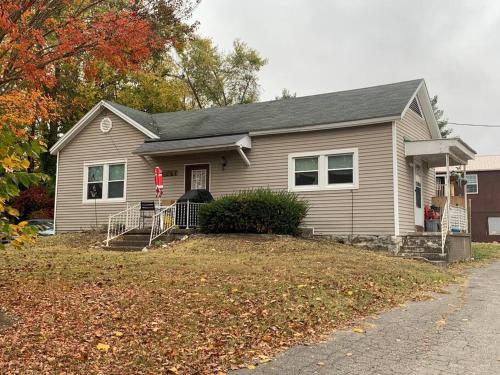 a gray house with a yard with a driveway at Chic Home Away From Home! in Bowling Green