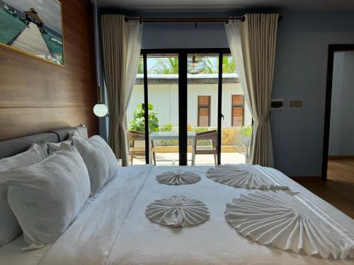 a white bed with white pillows on top of it at One Beach Resort By EHM in Koh Rong Sanloem