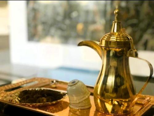 uma chaleira dourada e um prato de comida sobre uma mesa em فندق المأمون - ALMAMOUN HOTEL em Al Madinah