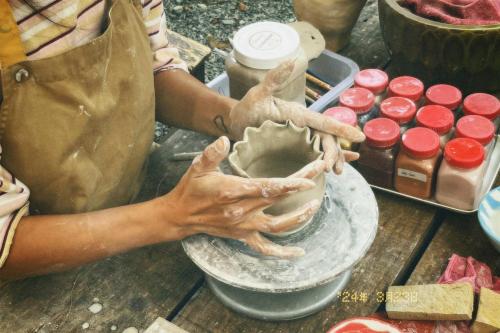 a woman making a bowl on top of a table at Nấp Đà Lạt in Da Lat