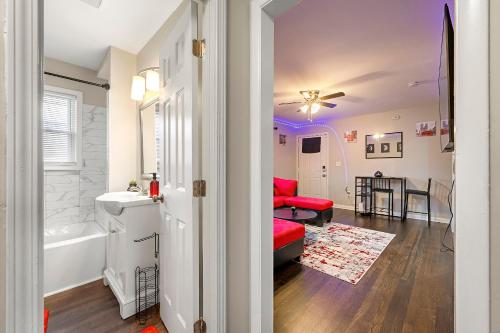 a living room with a red couch and a bathroom at Chill Pad Deluxe by MARTA/Downtown/Midtown/Hartsfield Jackson Airport in Atlanta