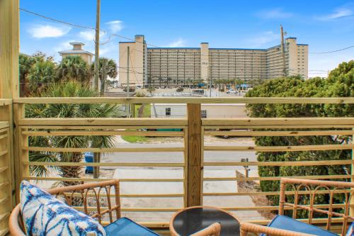 a balcony with chairs and a view of a building at OceanView Oasis - Relax with Hot Tub, Breakfast, Fire Pit & Putting Green! in Panama City Beach