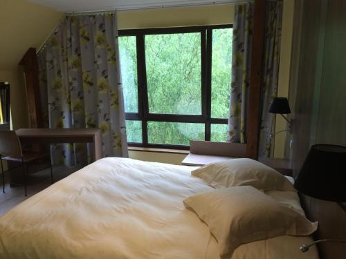 ein Schlafzimmer mit einem großen weißen Bett und einem Fenster in der Unterkunft Chambres d'Hotes Chez Marie in Seltz