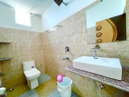 La salle de bains est pourvue d'un lavabo, de toilettes et d'un miroir. dans l'établissement Hotel Corel Suit Swimming Pool Hotel, à Purî