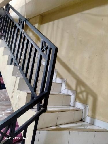 eine Treppe in einem Gebäude mit Treppengeländer in der Unterkunft Ifrazim home palem ganda asri 2 in Meruya-hilir