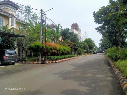 an empty street in a city with trees and flowers at Ifrazim home palem ganda asri 2 in Meruya-hilir