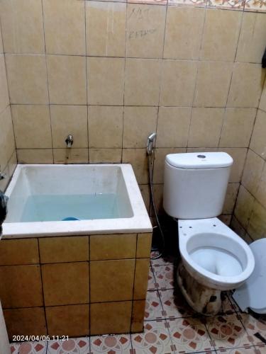 a bathroom with a toilet and a bath tub at Ifrazim home palem ganda asri 2 in Meruya-hilir