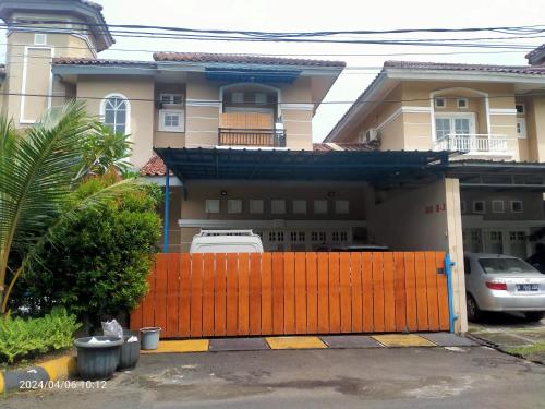 a house with a orange fence in front of it at Ifrazim home palem ganda asri 2 in Meruya-hilir