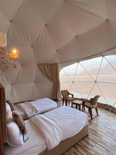 1 dormitorio con 2 camas en una tienda de campaña en Wadi Rum palace, en Wadi Rum