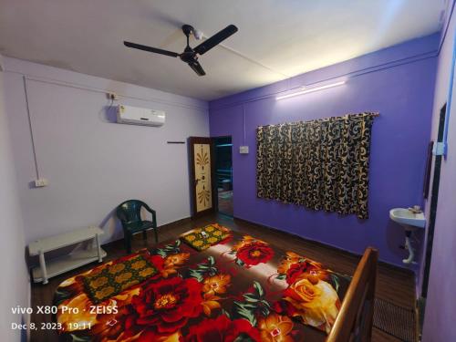 una camera con un letto fiorito di Mahalaxmi home stay tarkarli devbag beach a Bhogwe