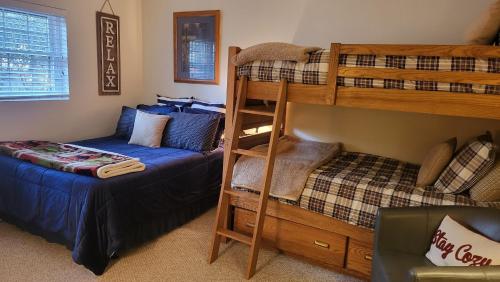a bedroom with two bunk beds and a bed at Boulder Lake-scape by AvantStay Lakefront Views Indoor Hot Tub Game Room in Lake Harmony