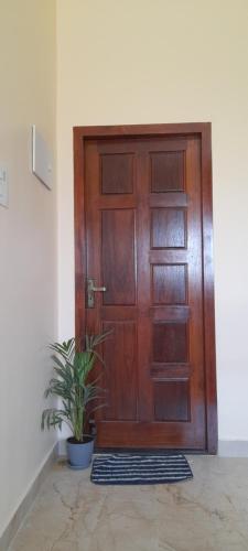 a wooden door with a potted plant in front of it at Priya home in Tiruvannāmalai