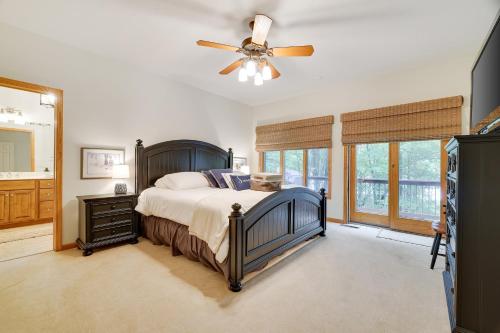 1 dormitorio con 1 cama y ventilador de techo en Elk Hollow by AvantStay Lakefront Chalet w Game Room Fire Pit, en Blakeslee