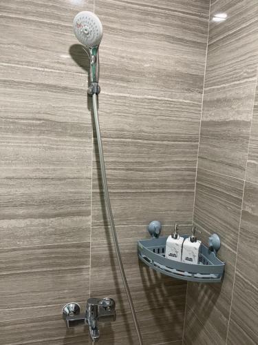 a shower with a shower head in a bathroom at Khu nghĩ dưỡng Emerald Golf View in Thuan An