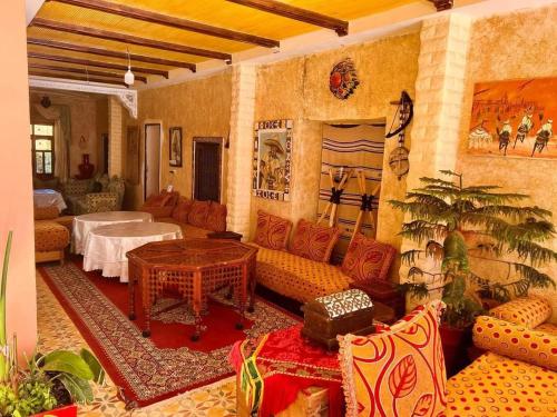 ein Wohnzimmer mit einem Sofa und einem Tisch in der Unterkunft maison d hote timentour in Tiguissas