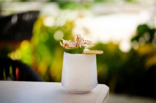 a white drink with a flower on top of it at Hotel Indigo Grand Cayman by IHG in Grand Cayman