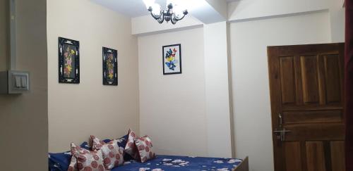 um quarto com uma cama e uma porta e algumas fotos em Silver Sun Official em Darjeeling