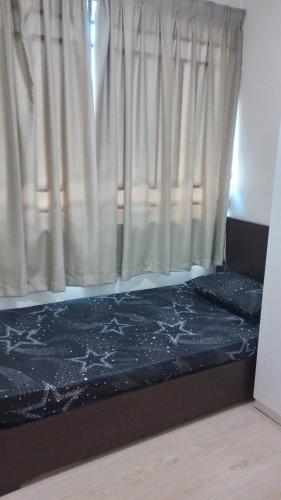 Bett in einem Zimmer mit Fenster in der Unterkunft Santai Homestay in Kota Kinabalu