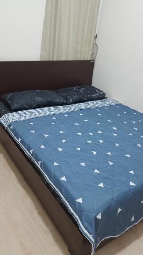 Bett in einem Zimmer mit blauer Decke in der Unterkunft Santai Homestay in Kota Kinabalu