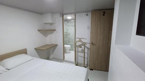 a bedroom with a bed and a bathroom with a toilet at Hotel Adel in Manizales