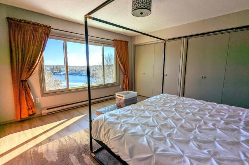 ein Schlafzimmer mit einem Bett und einem großen Fenster in der Unterkunft Emerald Bluff by AvantStay Lake Views Deck Fire Pit Game Room in Long Pond