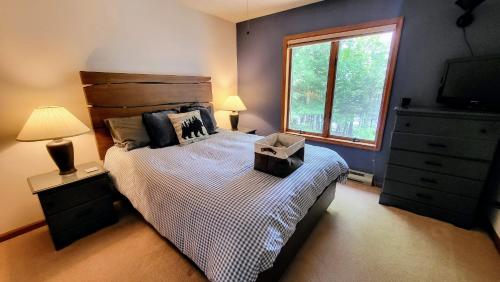 a bedroom with a bed with a dresser and a window at Tranquil Waterside by AvantStay Lakefront Dock Game Room Views in Pocono Summit