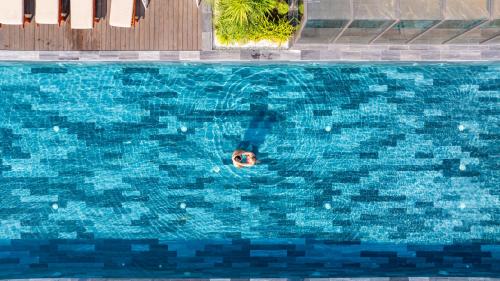 a person swimming in a large swimming pool at Golden Lotus Grand in Danang