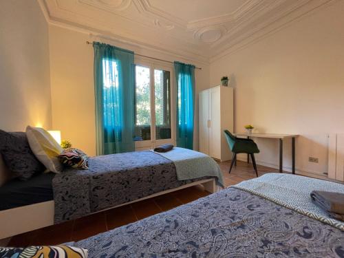 a bedroom with two beds and a desk and a window at Arc De Triumph Rooms in Barcelona