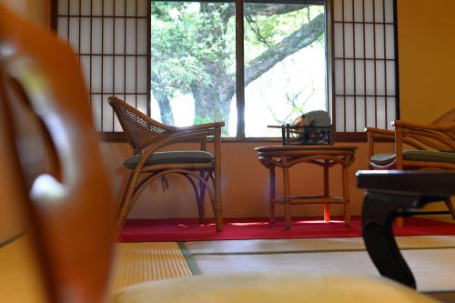 a room with chairs and a table and a window at Kotonoyado Musashino in Nara