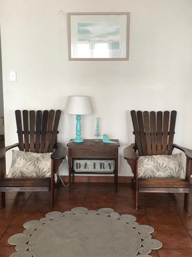 a living room with two chairs and a table with a lamp at On the Rocks @ Eersterivier in Eersterivierstrand