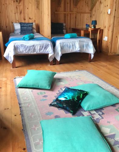 two beds in a room with green pillows on the floor at On the Rocks @ Eersterivier in Eersterivierstrand