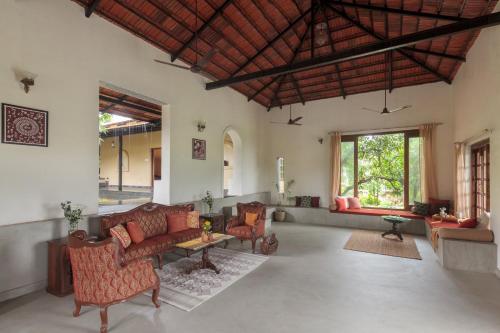 a living room with couches and a table at StayVista's Basalt - with Mountain Views, Infinity Pool, Vintage Interiors, and Games Room in Karjat