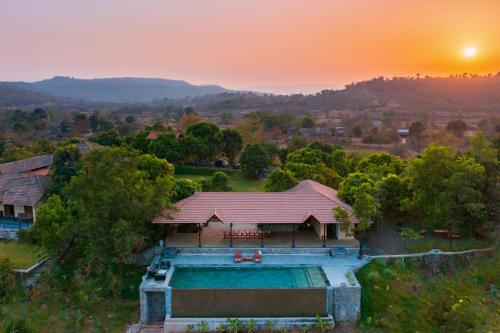 an aerial view of a house with a swimming pool at StayVista's Basalt - with Mountain Views, Infinity Pool, Vintage Interiors, and Games Room in Karjat