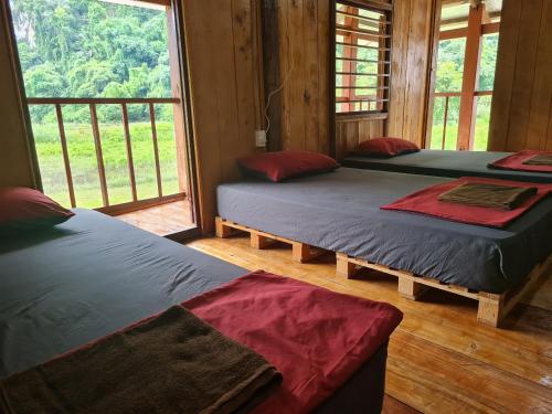 - 3 lits dans une chambre avec fenêtre dans l'établissement Ba Be Retreat house, à Bak Kan