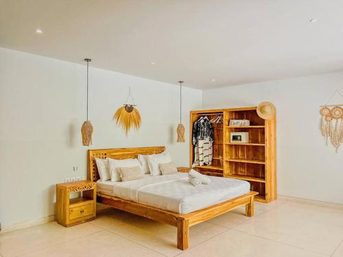 a bedroom with a bed and a book shelf at Marlaca Villas Lombok in Kuta Lombok