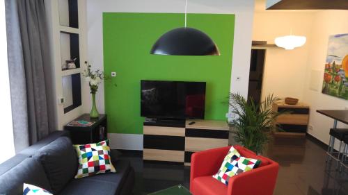 - un salon avec un canapé et un mur vert dans l'établissement Apartment Rhein Main, à Hochheim am Main
