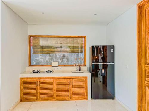 a kitchen with a sink and a refrigerator at Marlaca Villas Lombok in Kuta Lombok