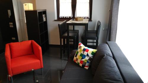 - un salon avec un canapé et un fauteuil rouge dans l'établissement Apartment Rhein Main, à Hochheim am Main