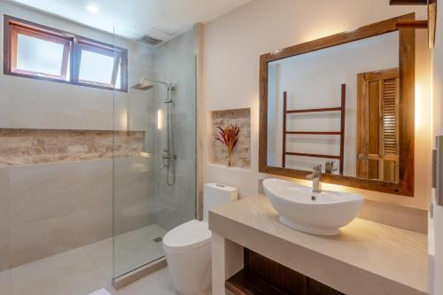 a bathroom with a sink and a glass shower at Bulan Villas Siargao in General Luna