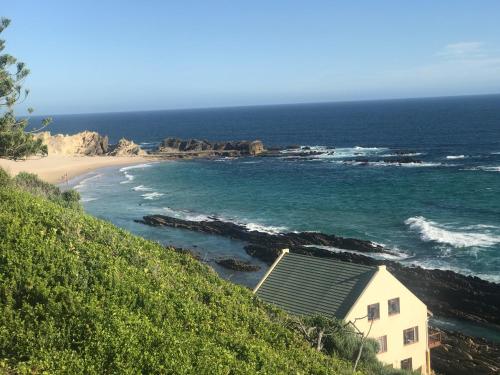 a house on a hill next to a beach at On the Rocks @ Eersterivier in Eersterivierstrand