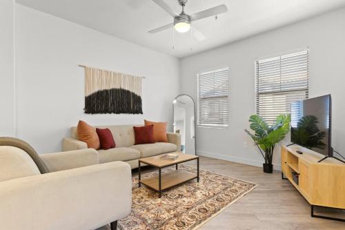 a living room with a couch and a tv at CozySuites Glendale by the stadium with pool 16 in Glendale
