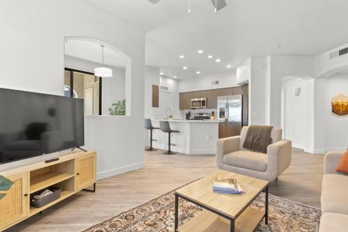 a living room with a large flat screen tv at CozySuites Glendale by the stadium with pool 16 in Glendale
