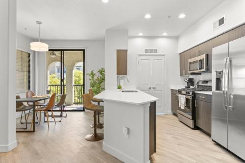 a kitchen with a counter and a table with chairs at CozySuites Glendale by the stadium with pool 16 in Glendale