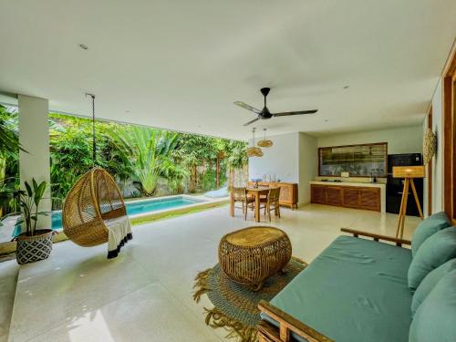 an open living room with a table and chairs at Marlaca Villas Lombok in Kuta Lombok