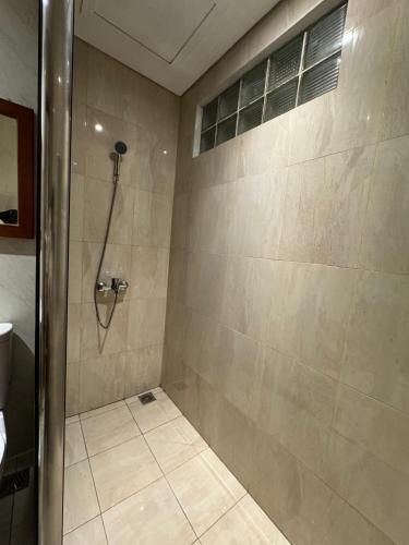 a bathroom with a shower with a glass door at Sukajadi Hotel, Convention and Gallery in Bandung